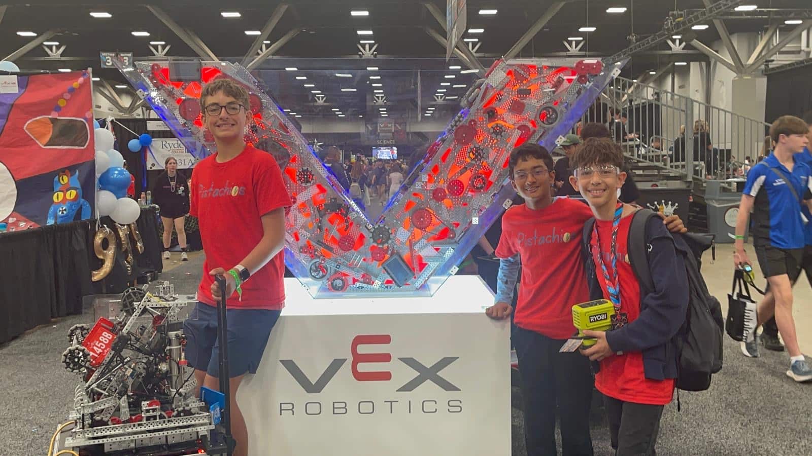Students posing with robot at VEX Robotics booth
